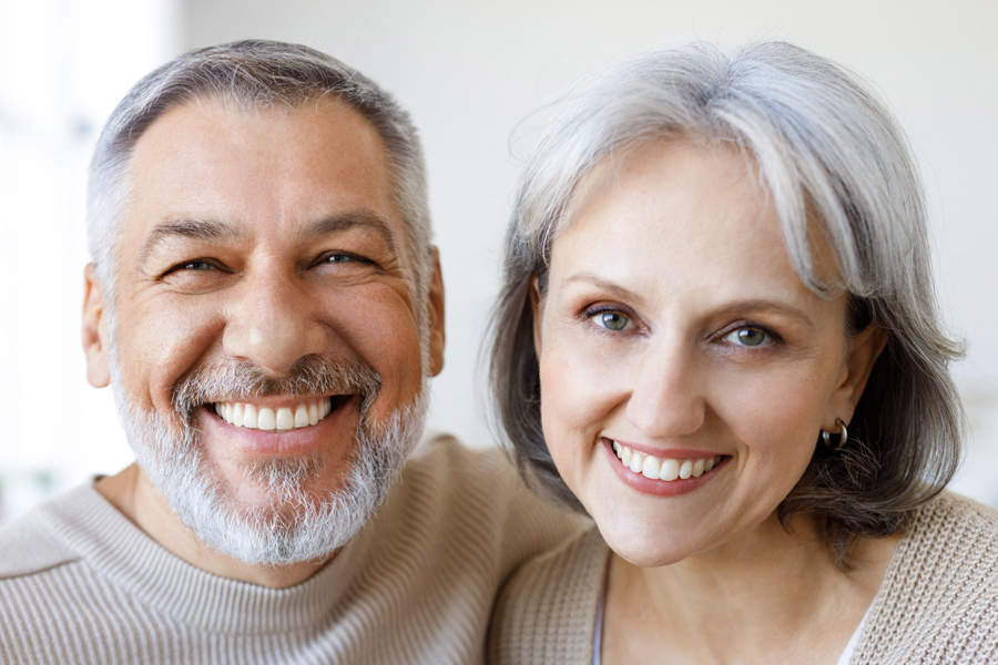 Happy smiling older older couple show off their dental crowns